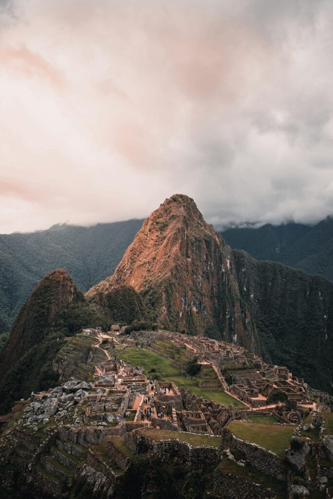 Explore the stunning aerial perspective of Machu Picchu, nestled in lush Peruvian mountains.